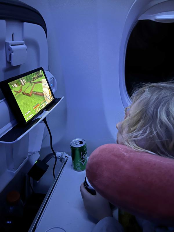 Mia on the airplane playing Nintendo heading home from Florida